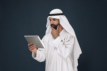 Image showing Arabian saudi businessman on dark blue studio background