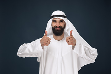 Image showing Arabian saudi man on dark blue studio background