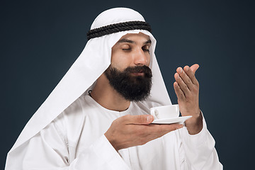 Image showing Arabian saudi man on dark blue studio background