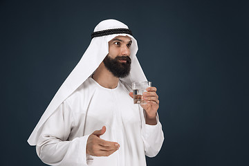 Image showing Arabian saudi man on dark blue studio background