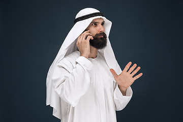 Image showing Arabian saudi man on dark blue studio background