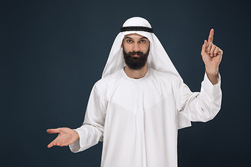 Image showing Arabian saudi man on dark blue studio background