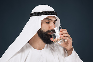 Image showing Arabian saudi man on dark blue studio background