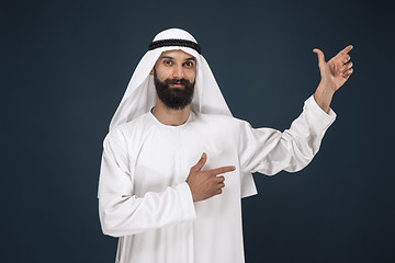 Image showing Arabian saudi man on dark blue studio background