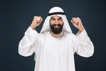 Image showing Arabian saudi man on dark blue studio background