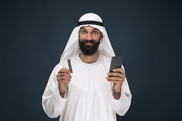 Image showing Arabian saudi man on dark blue studio background