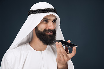 Image showing Arabian saudi man on dark blue studio background