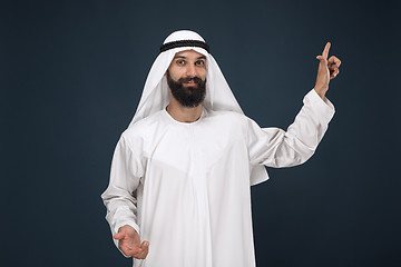 Image showing Arabian saudi man on dark blue studio background