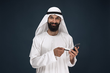 Image showing Arabian saudi man on dark blue studio background