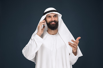 Image showing Arabian saudi man on dark blue studio background