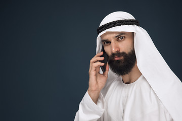 Image showing Arabian saudi man on dark blue studio background