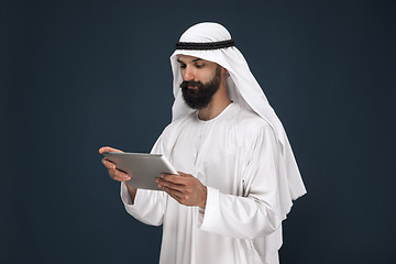 Image showing Arabian saudi businessman on dark blue studio background