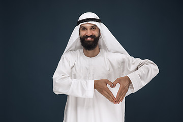 Image showing Arabian saudi man on dark blue studio background