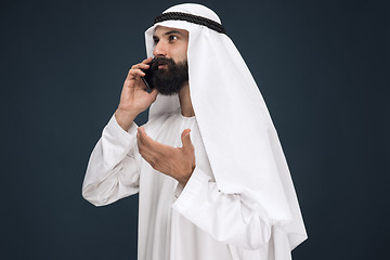 Image showing Arabian saudi man on dark blue studio background