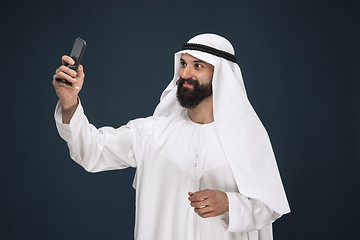 Image showing Arabian saudi man on dark blue studio background