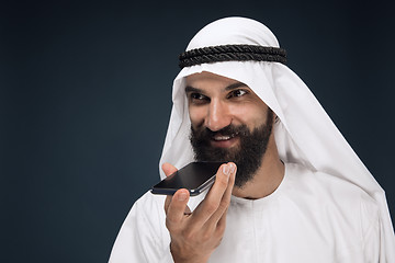 Image showing Arabian saudi man on dark blue studio background