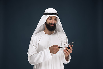 Image showing Arabian saudi man on dark blue studio background