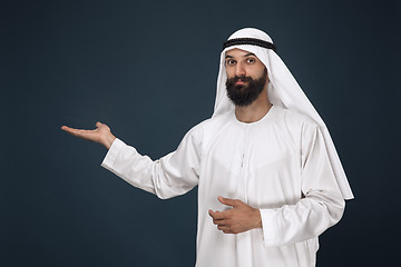 Image showing Arabian saudi man on dark blue studio background