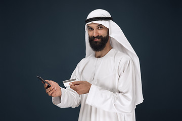 Image showing Arabian saudi man on dark blue studio background