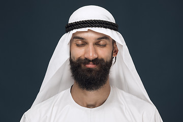 Image showing Arabian saudi man on dark blue studio background