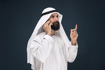 Image showing Arabian saudi man on dark blue studio background