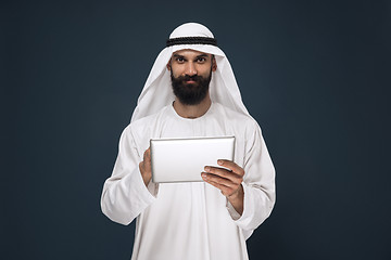 Image showing Arabian saudi businessman on dark blue studio background