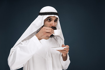 Image showing Arabian saudi man on dark blue studio background