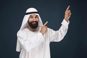 Image showing Arabian saudi businessman on dark blue studio background