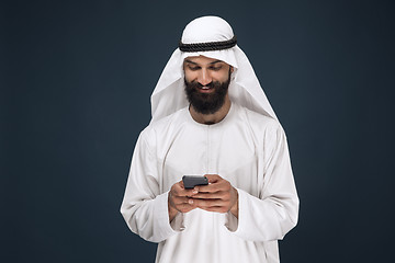 Image showing Arabian saudi man on dark blue studio background