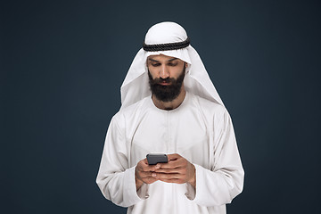 Image showing Arabian saudi man on dark blue studio background