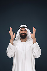 Image showing Arabian saudi businessman on dark blue studio background