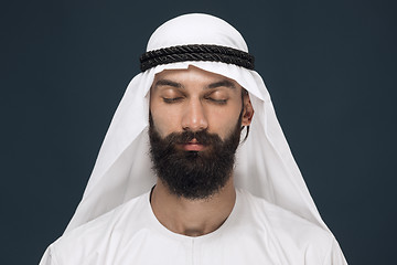 Image showing Arabian saudi man on dark blue studio background