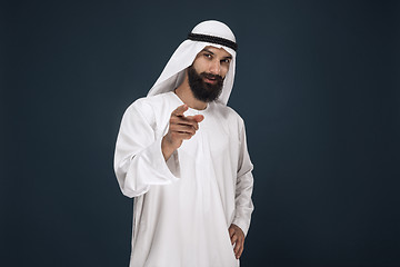 Image showing Arabian saudi businessman on dark blue studio background