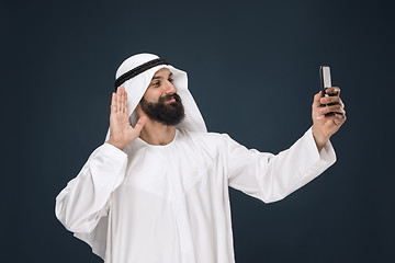 Image showing Arabian saudi man on dark blue studio background