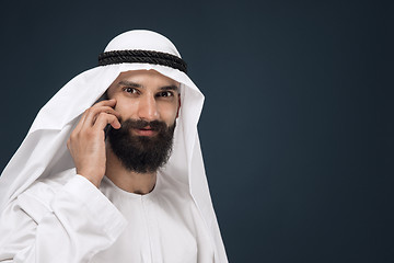 Image showing Arabian saudi man on dark blue studio background