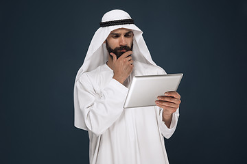 Image showing Arabian saudi businessman on dark blue studio background