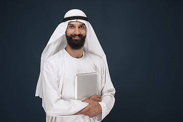 Image showing Arabian saudi businessman on dark blue studio background