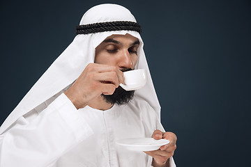 Image showing Arabian saudi man on dark blue studio background