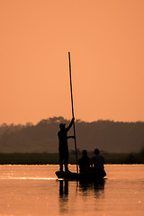 Image showing Men in a boat on a river silhouette