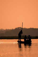 Image showing Blurred Men in a boat on a river silhouette