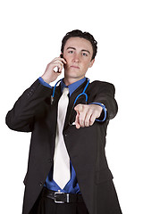 Image showing Young doctor talking on a cell phone and Pointing