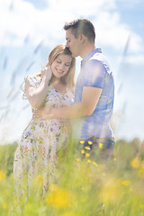 Image showing Young happy pregnant couple hugging in nature.