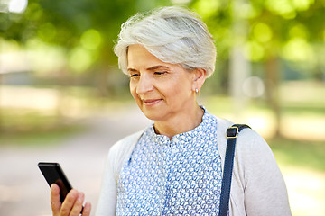 Image showing happy senior woman with smartphone at summer park