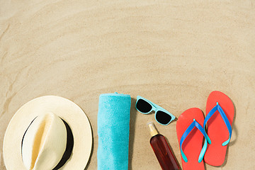 Image showing straw hat, flip flops and sunglasses on beach sand