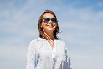 Image showing happy smiling woman in sunglasses over sky