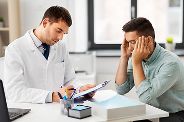 Image showing doctor with clipboard and male patient at hospital