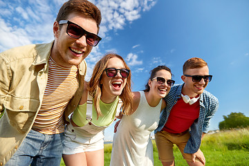 Image showing happy teenage friends laughing outdoors in summer