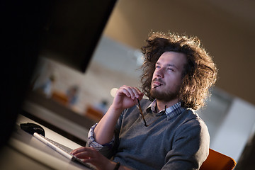 Image showing man working on computer in dark office