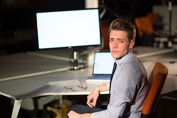 Image showing man working on computer in dark office