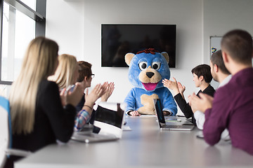 Image showing boss dresed as bear having fun with business people in trendy of